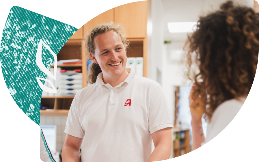 Adrian Neumann Landapotheken Ein Apotheker spricht freundlich mit einer Patientin. Sie befinden sich in der Schloßapotheke.